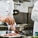 2 chefs preparing food in a restaurant kitchen